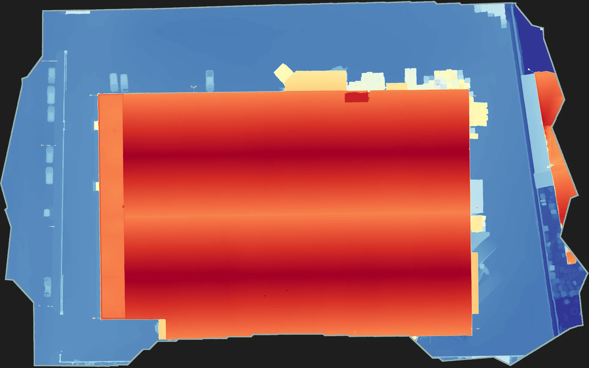 Modelo digital de superficies de una nave industrial obtenido con dron: la cubierta aparece en rojo y la explanada en azul